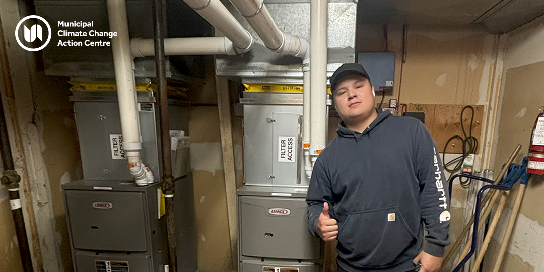 Man stands in front of new high-efficiency furnace in High Prairie